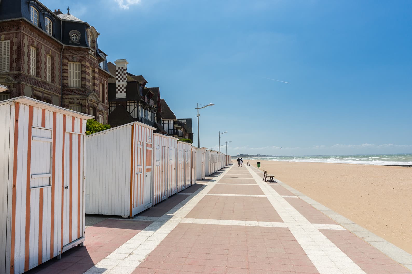 Image de la promenade de Houlgate en plein soleil avec les cabine de plage