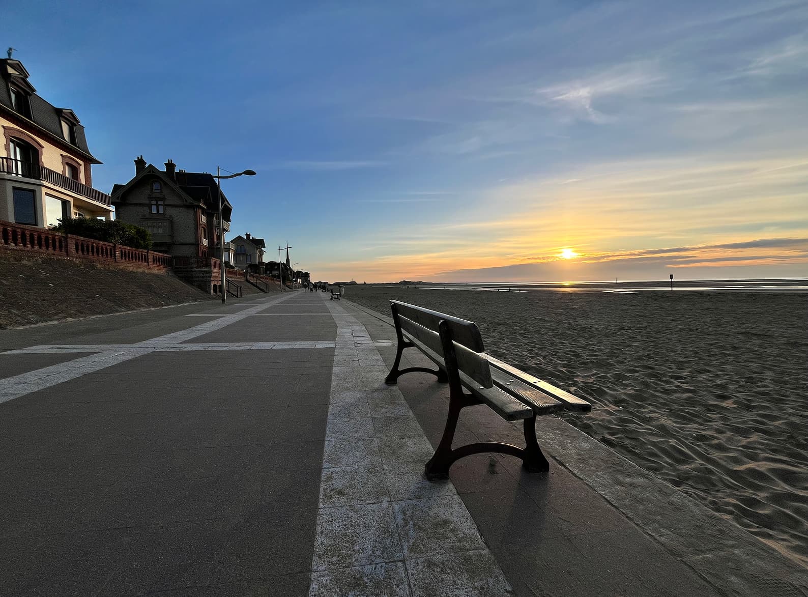 Image d'un banc sur la promenade de Houlgate au coucher de soleil